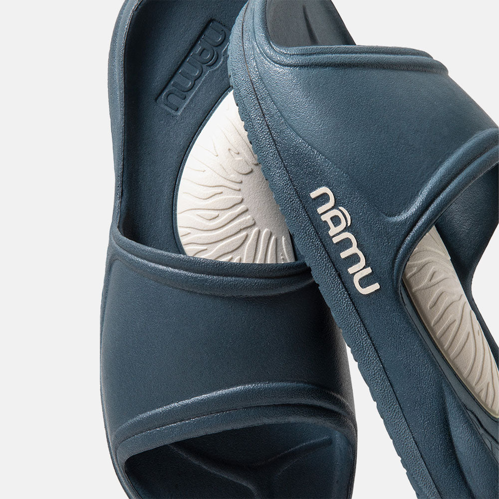 Pair of blue sandals with 'nubu' branding on a light gray background