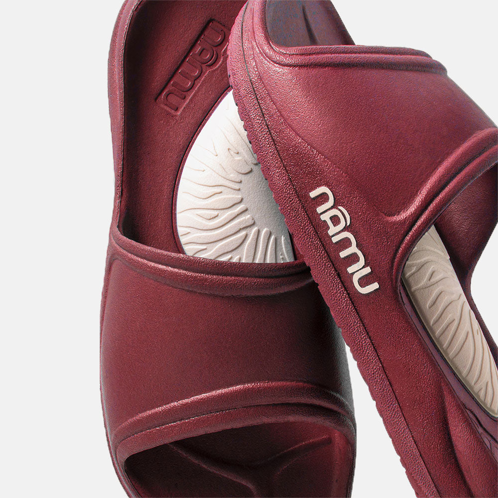 Maroon sandals with 'nubu' branding on a light gray background