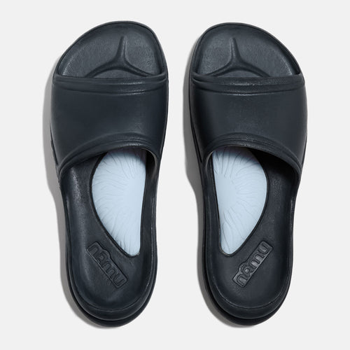 Pair of black slides with light blue insoles on a white background